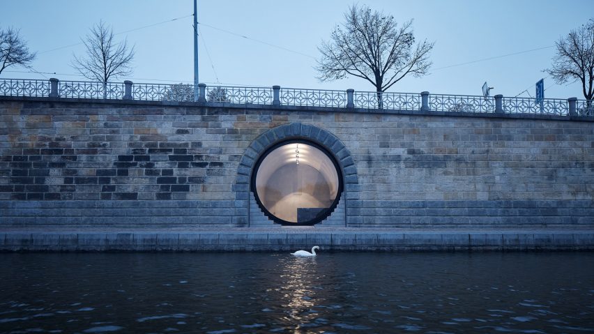 A swan is pictured paddling past a glass fronted vault