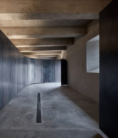 Toilet cubicles are zoned by a curving metal wall