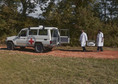 Two medics carry an incubator to an ambulance