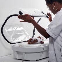 A woman lifts the lid to the Robust Nest incubator