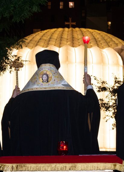 Priest outside illuminated church