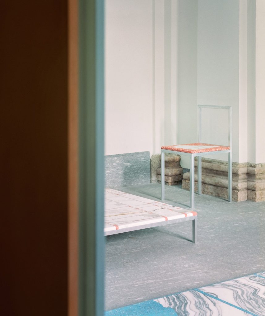 View of chair, coffee table and flooring in The Stone House exhibition
