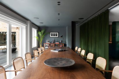 A large meeting table with rattan dining chairs