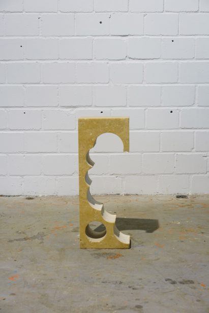 Teil 2 tall travertine side table with cylindrical cutouts along one side