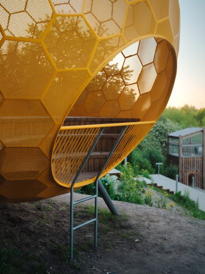 A metal ladder leads into the orange sphere