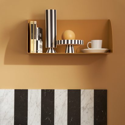 A yellow shelf above a marble countertop