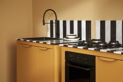 A yellow kitchen unit with a sink and oven