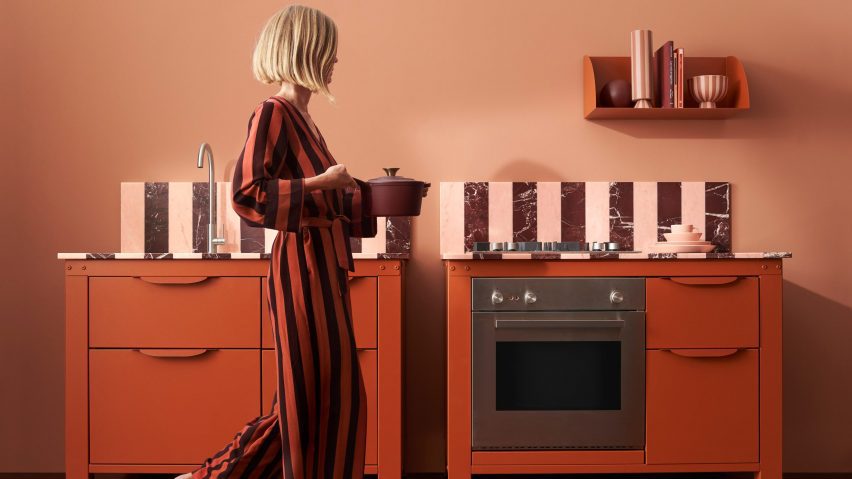 A woman walking through a red kitchen