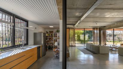 An open plan living room and kitchen in an unfinished style