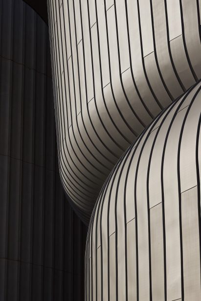 The zinc panels curve around the stacked volumes