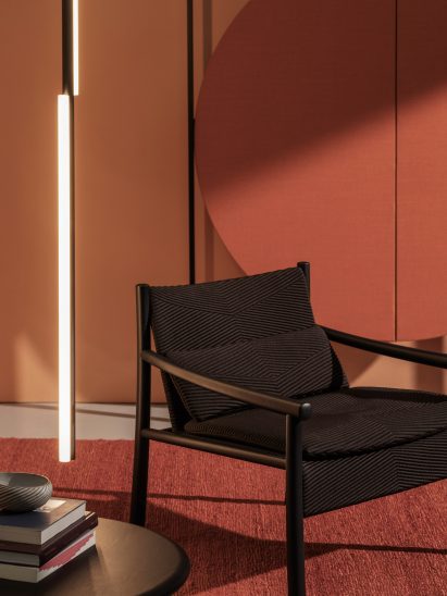 The Kata chair in black situated in a bright red interior with an accompanying side table
