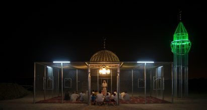 People gather inside the steel mosque at night