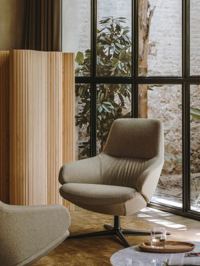 Grey Aston Club Low Back seat in a living room interior with a four-star base