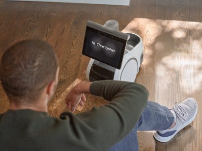 A man sits on the floor with an Astro robot