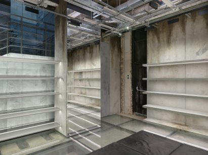 Shelving and mirrors line the stained concrete walls 