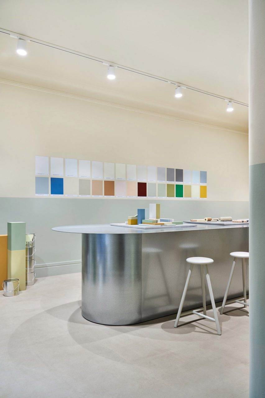 Galvanised steel table in front of a wall of paint swatches in the Cover Story Helsinki store
