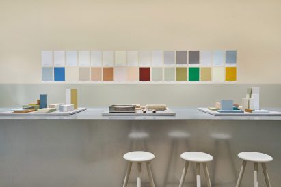 Stools in front of steel benches topped with colourful painted blocks