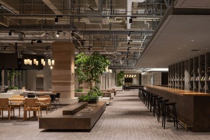 Workspace interior by Flooat with wooden desks and bar seating