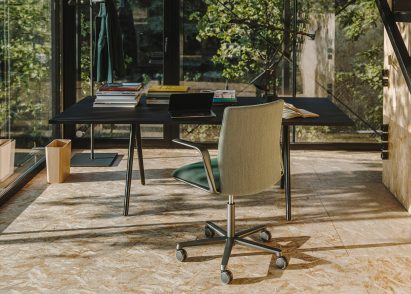 The back of a forest green Kinesit Met office chair at a desk in a home office environment