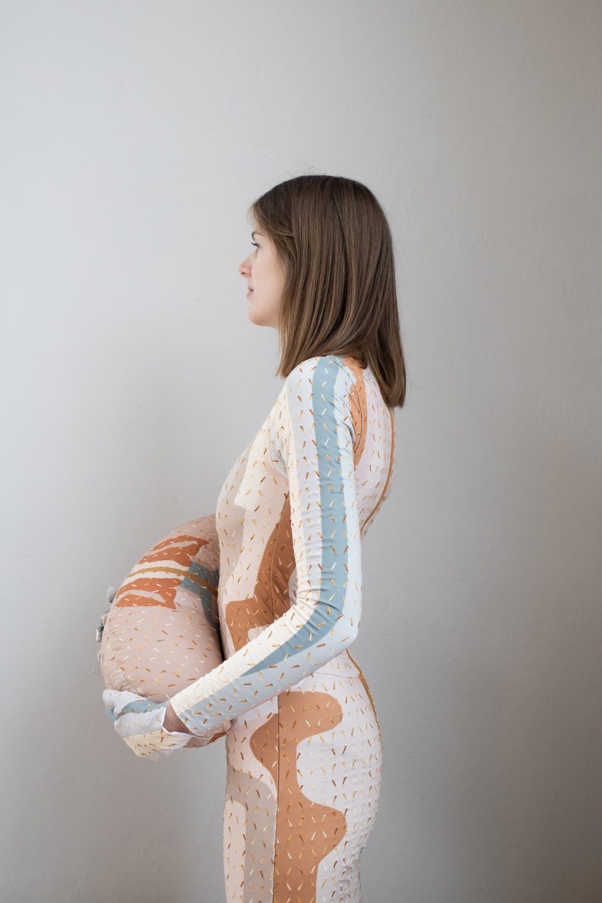 Woman wearing a Healing Imprint therapeutic garment with a meridian print and holding a matching pillow
