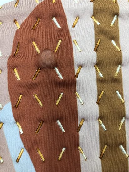 The Healing Imprint garment with a massage ball positioned in a valley of one channel