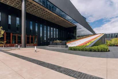The ramp has concrete steps, plants and a synthetic track