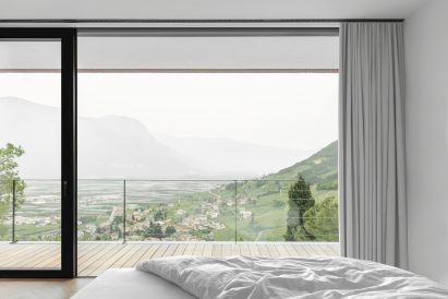 A bedroom at Kastelaz Hof has full height windows and a terrace