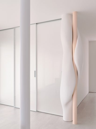 Wooden column in home interior by OPA is enveloped by a white, cloud-shaped intervention