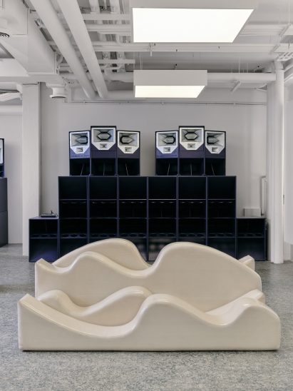 A wall of speakers occupies the rear of the showroom space