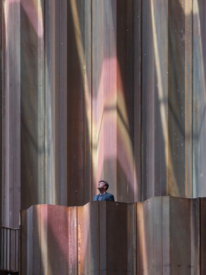 A person stands under coloured, patterned light inside the Dutch Biotope pavilion