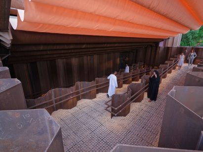Visitors walk under an orange-coloured canopy at the Expo 2020 Dubai