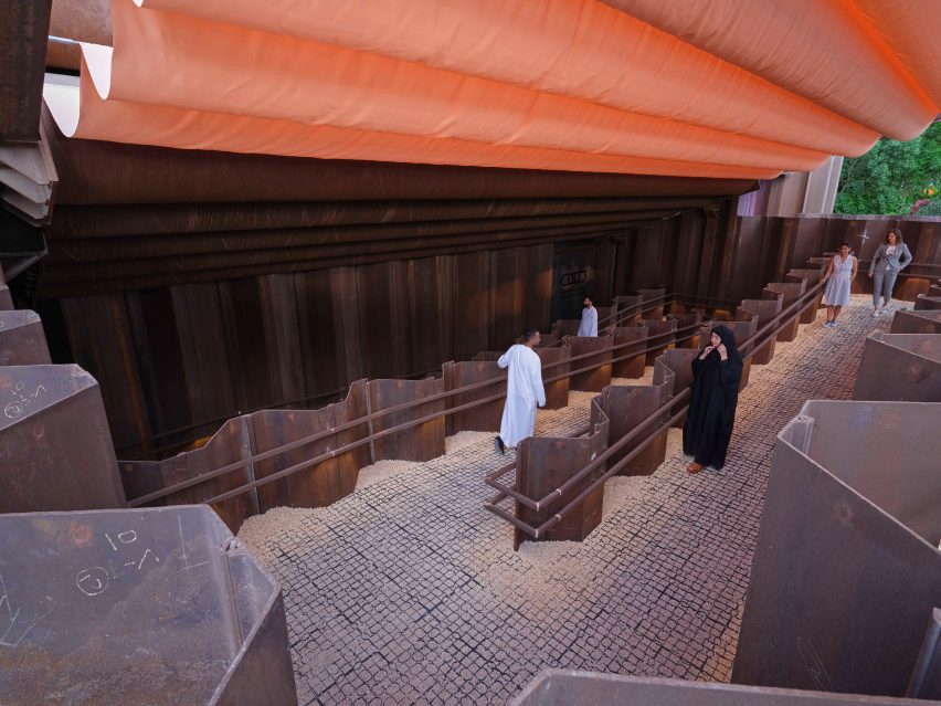 Visitors walk under an orange-coloured canopy at the Expo 2020 Dubai