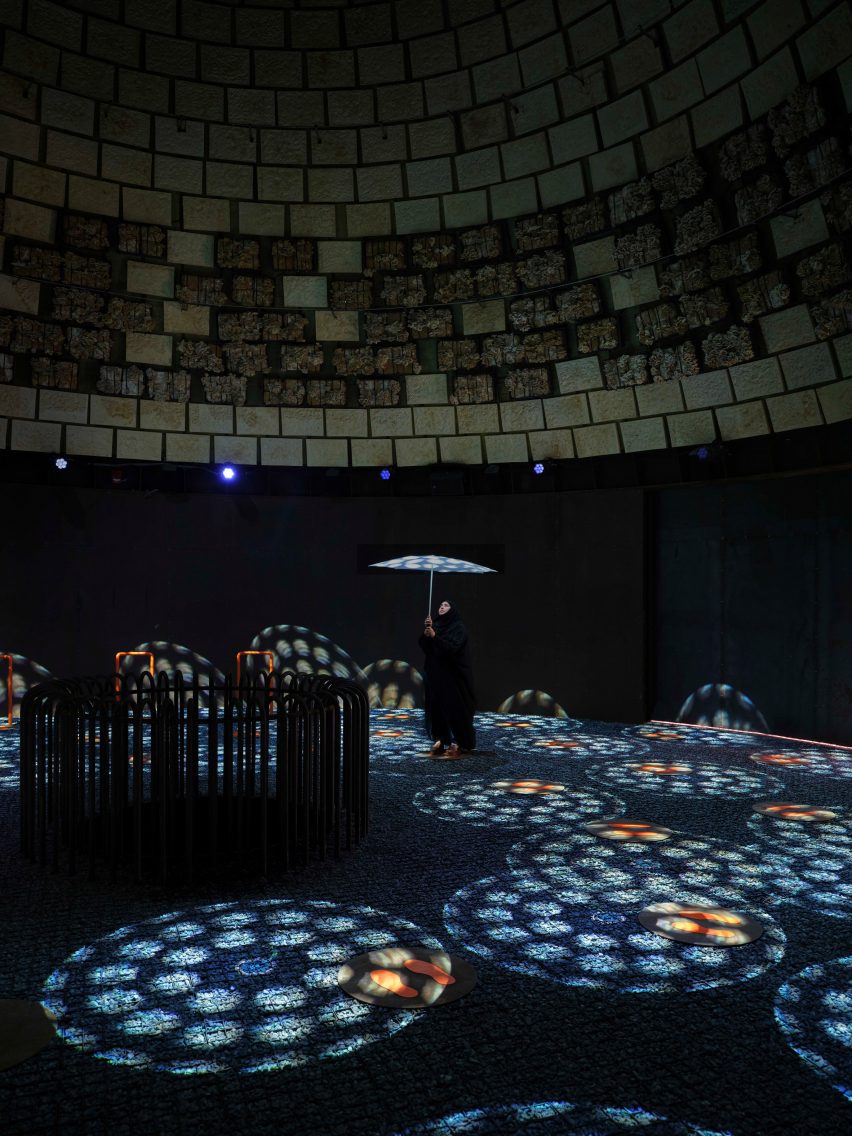 Colourful patterned projects on the floor of a dark circular room