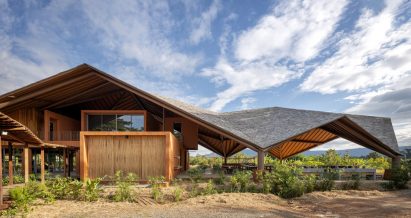 PANNAR Sufficiency Economic and Agriculture Learning Centre has wooden volumes beneath its roof