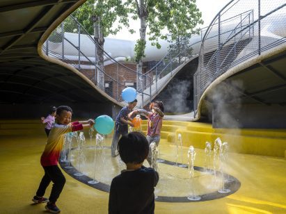 A fountain is built into the yellow floor of the playscape