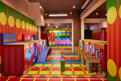 Interior of Yinka Ilori's colourful Launderette of Dreams with washing machine installations lining both sides of the room