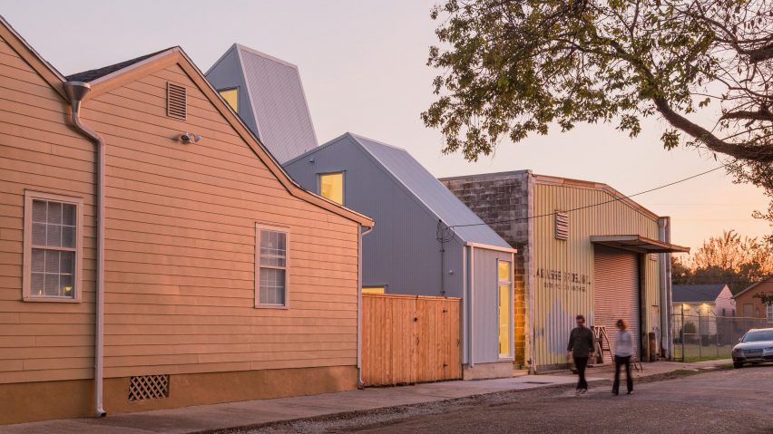 Corrugated house on a narrow suburban lot at dusk