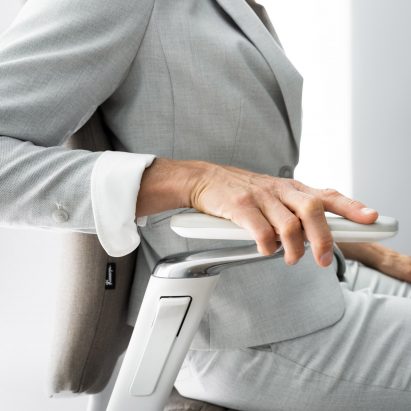 A photograph of a person resting their arm on a chair