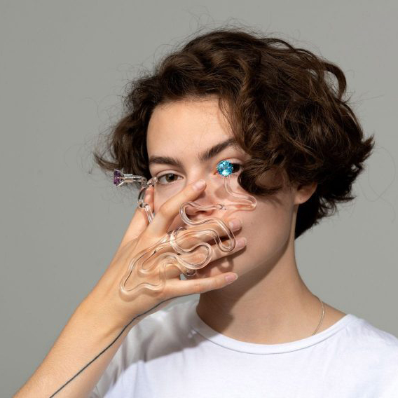 Person holding a piece of glass jewellery in front of their face