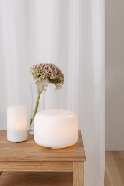 A photograph of a white diffuser by Muji with a glowing light inside it