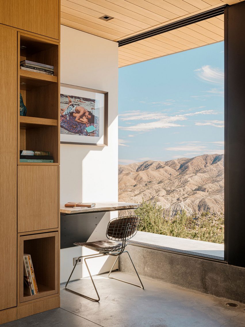 A studt next to window overlooking sunny mountains