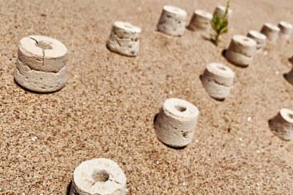 Row of desertification remediation vessels in sand