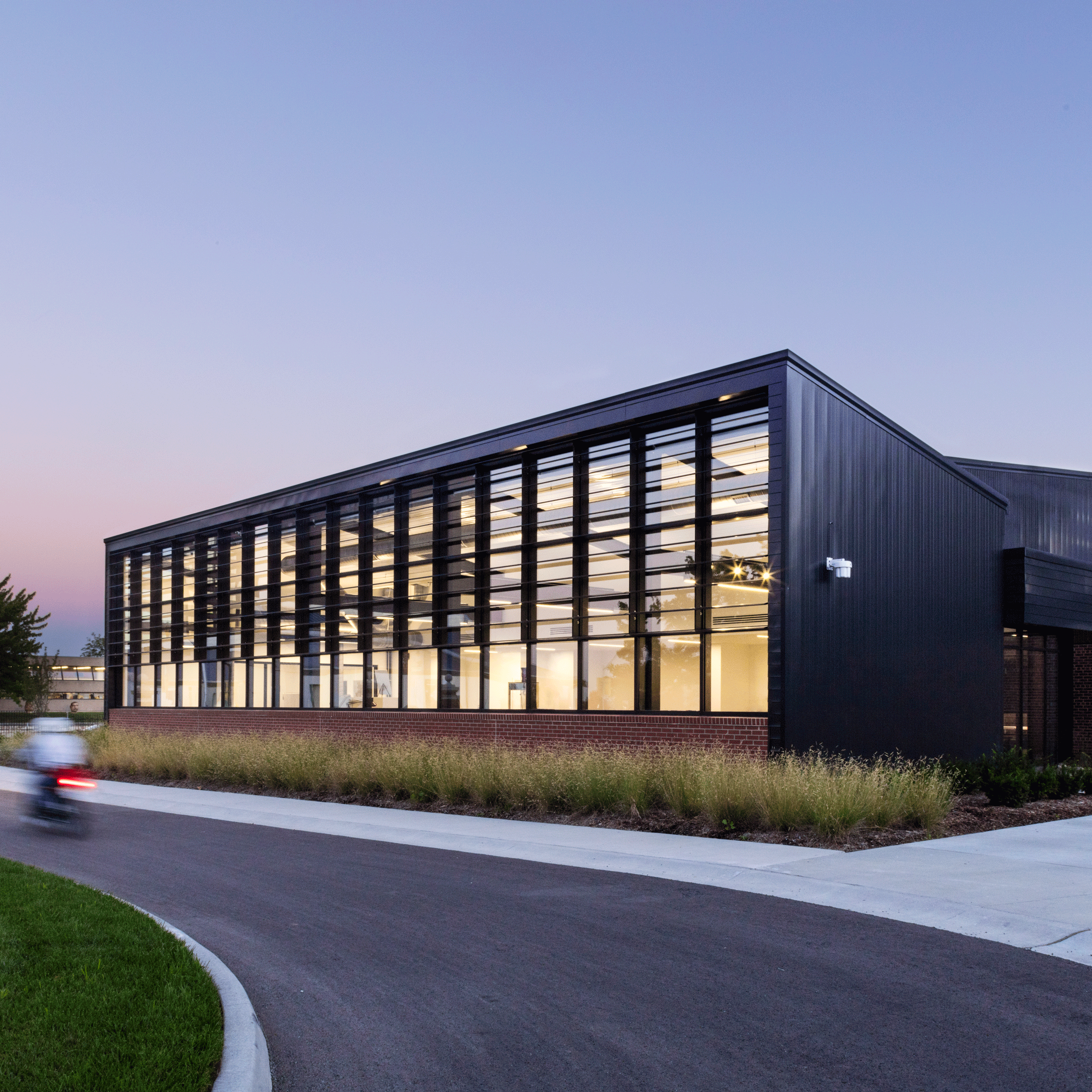 Black and glazed structure lit up in the evening