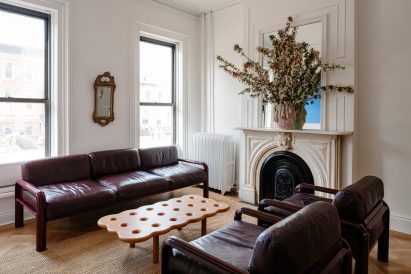 Living room with dark red sofas and restored fireplace