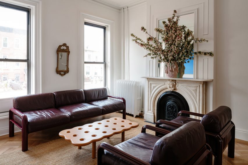 Living room with dark red sofas and restored fireplace
