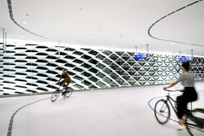 A man and woman cylce in Bicycle Garage the Hague