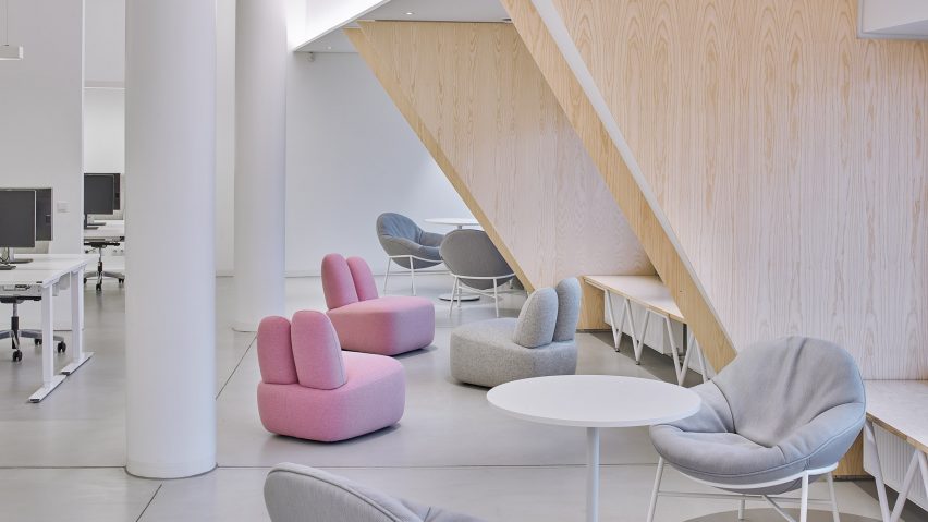Three Bunny lounge chairs in pink and grey situated within an office-like interior