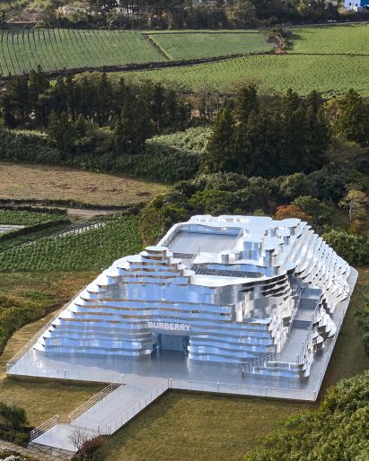A mirrored building in green countryside