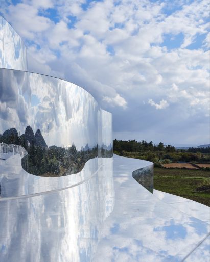 A mirrored building reflecting cloudy sky