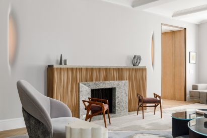 A living room with stools and armchairs in front of a fireplace